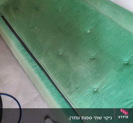 ספה ירוקה עם כרית, צינור ומטלית על הרצפה